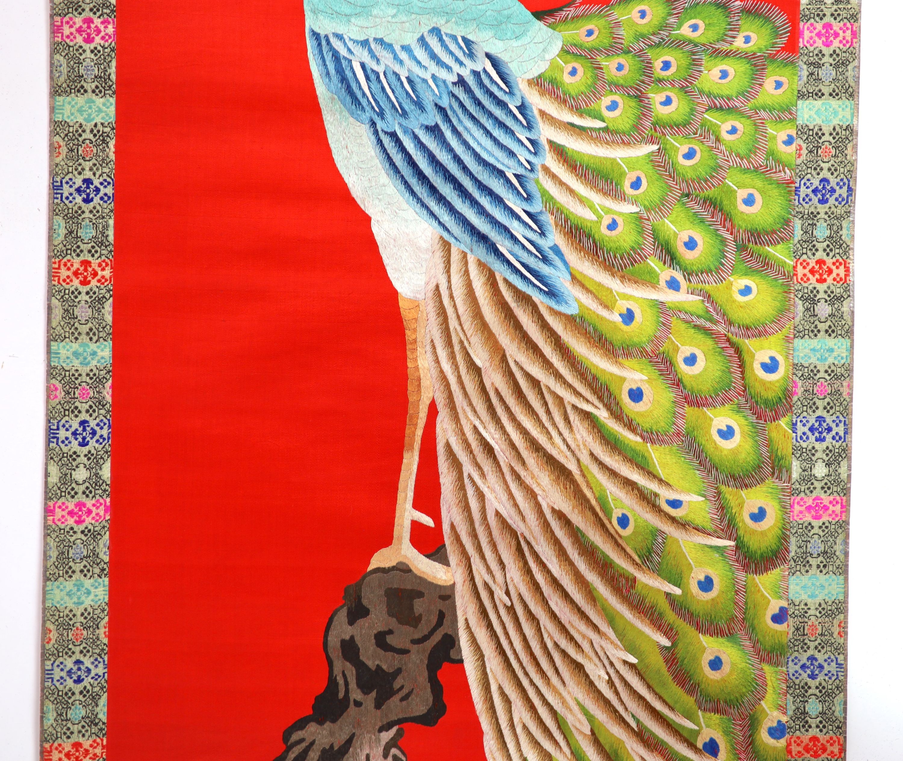 A Chinese embroidered silk ‘peacock’ scroll, late 19th century, 194 x 45 cm excluding brocade borders